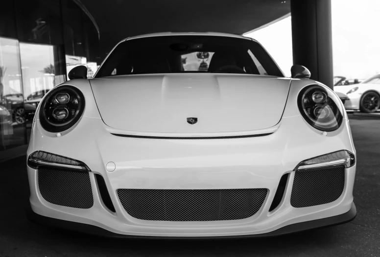 white porsche sports car parked in the parking lot