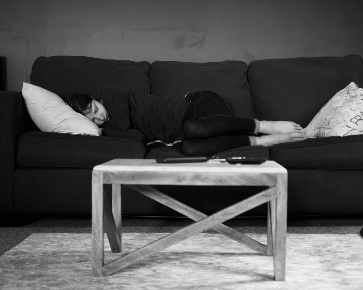 black and white pograph of two people sleeping on a couch