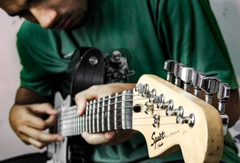 a close - up of a man playing an electric guitar