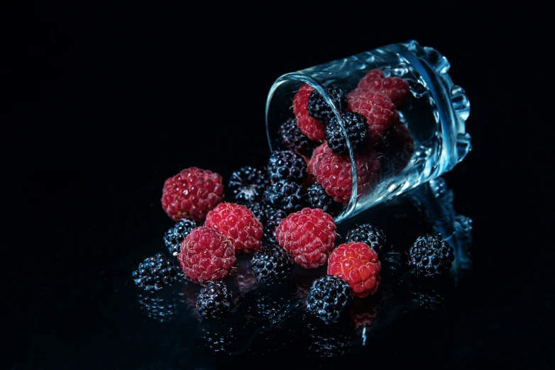 berries sit in a clear glass container as it hovers
