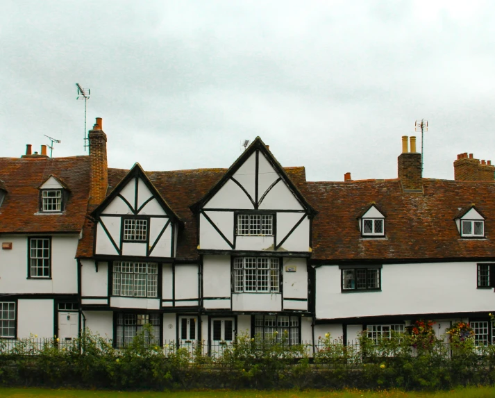 a row of three large buildings with chimneys in front