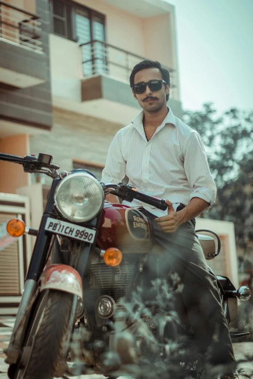 a man with sunglasses on his head sitting on a motorcycle