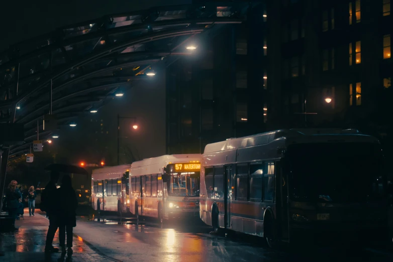 a bus station with buses parked at night