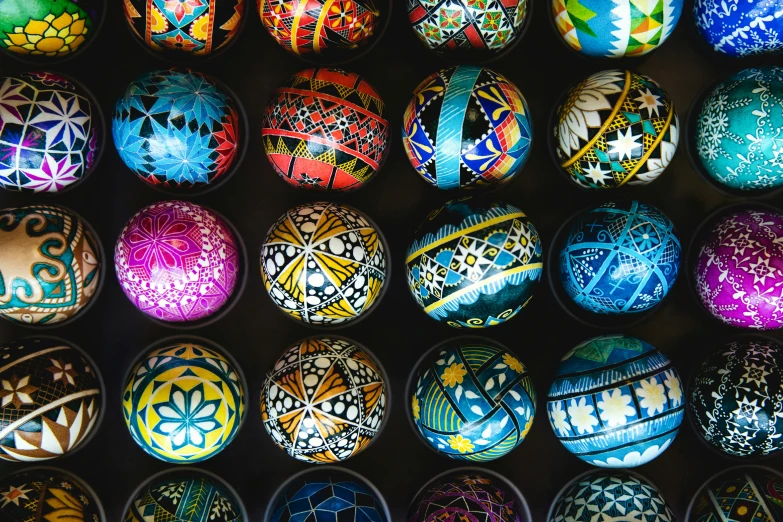 several brightly colored decorated eggs on a black background