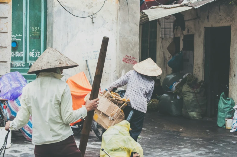 a man hing a cart with two women walking up the side of it