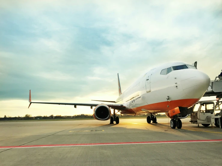 a white and orange jet is on a runway