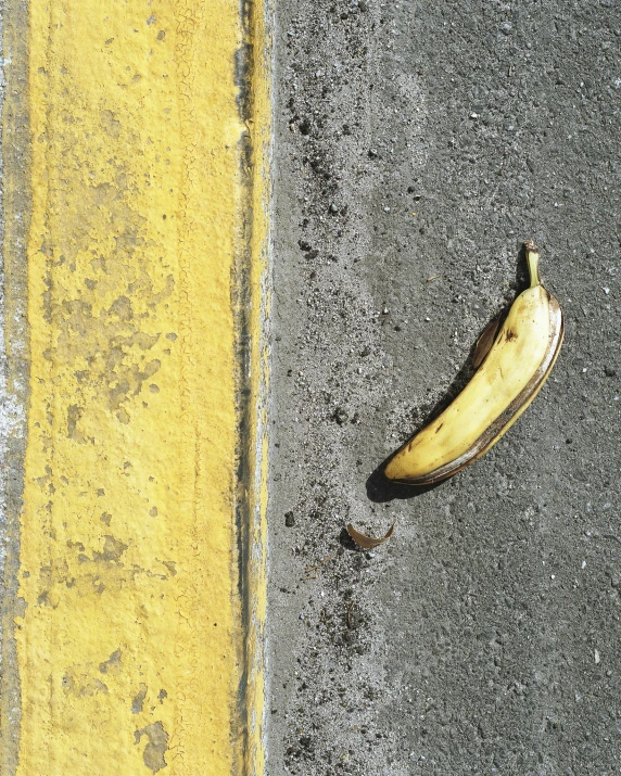 a peeled banana lies on the side of the road