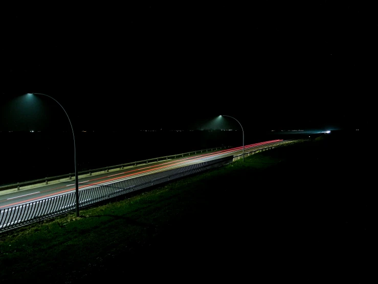 the highway is empty in the dark with cars driving