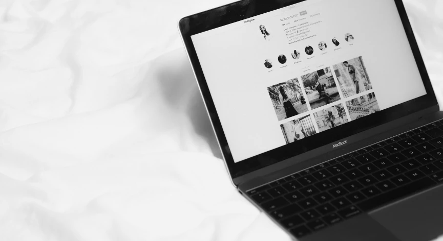 a laptop computer sits on the edge of a bed