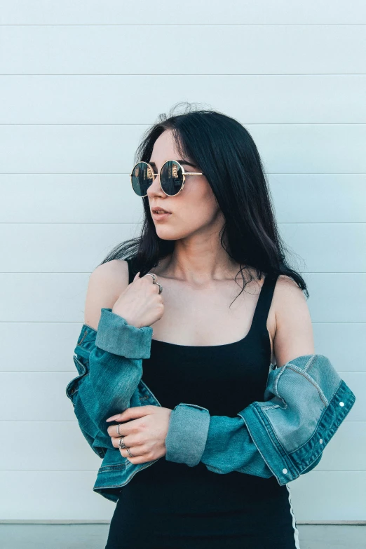 an attractive woman wearing a black dress and sunglasses