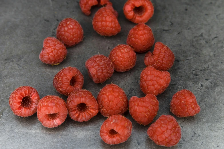 some raspberries and one of them has just been cut