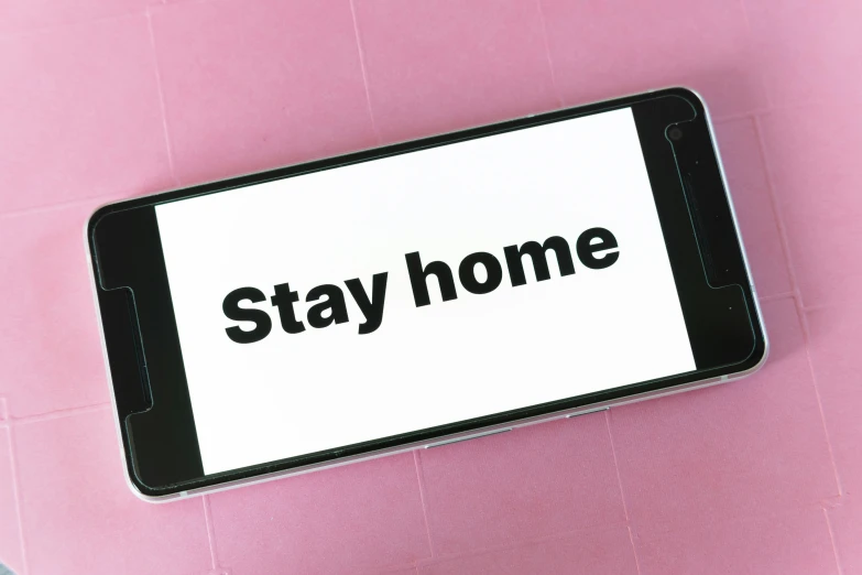 a cell phone with the words stay home printed on the screen