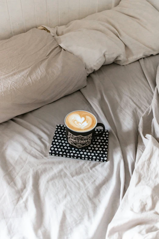 a coffee cup on top of a black and white polka dot blanket
