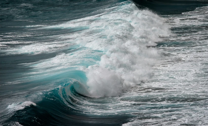 large waves breaking with small sprays crashing through the water
