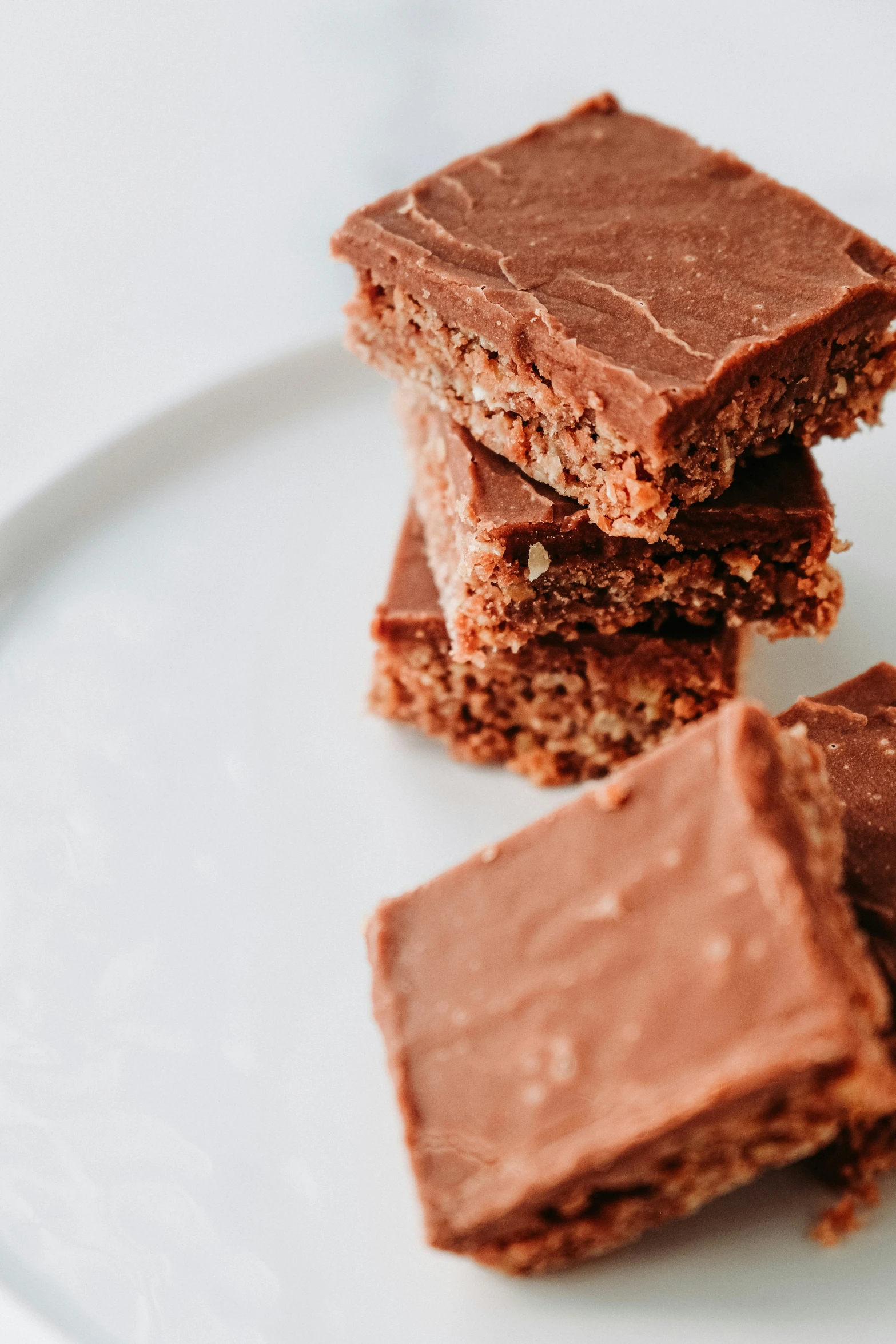 a white plate with three pieces of brownies on top of it