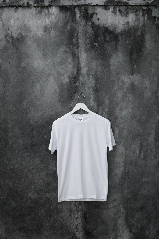 a white ts - shirt hanging on a stone wall