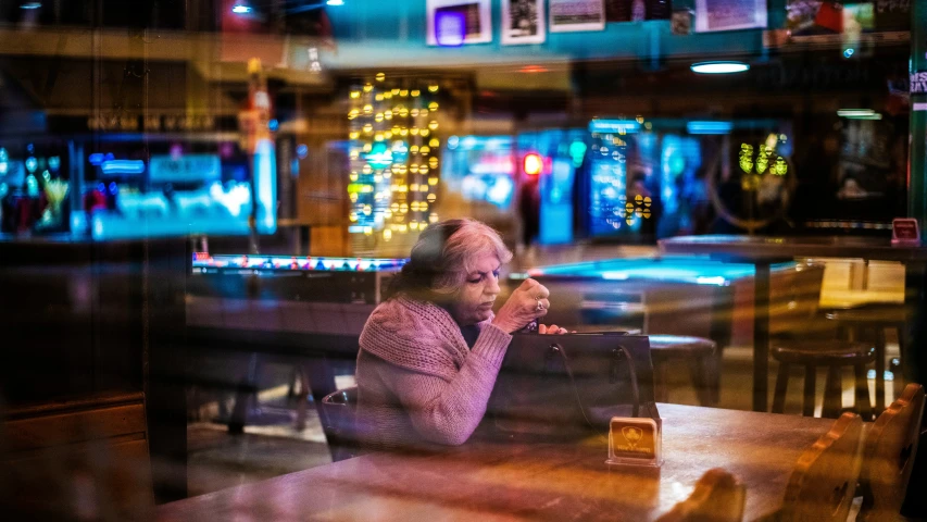 blurry pograph of a woman sitting at a restaurant table