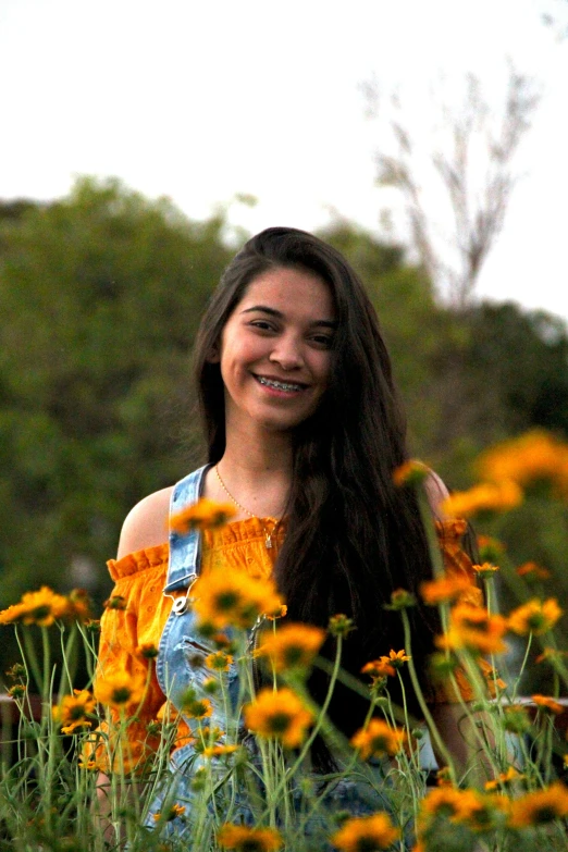 woman standing in the grass with wild flowers