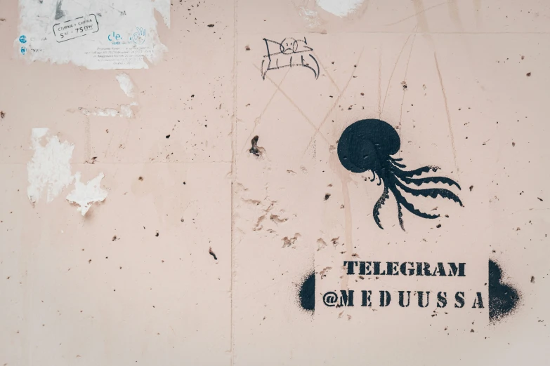 a wall covered with graffiti has writing and a painting of an octo