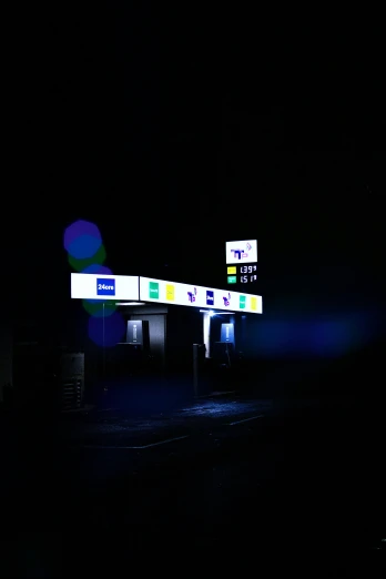 the gas station is lit up at night with lights