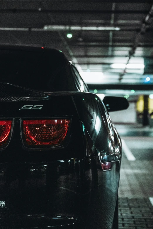 a car parked in a parking garage with it's lights on