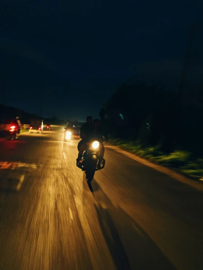 two people on a motorcycle riding down the road