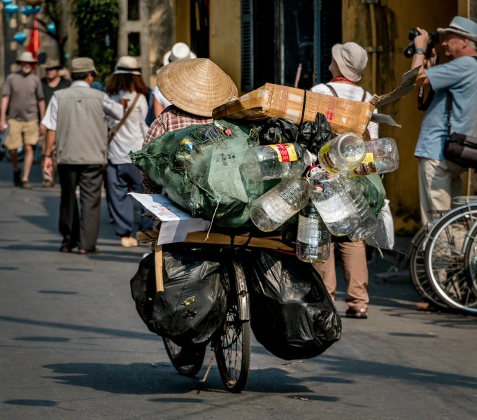 a man is riding his bike down the street carrying food