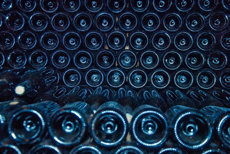 a bunch of wine bottles are stacked high