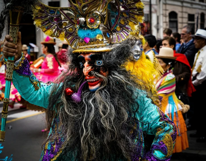 a man with long hair and long dark hair wearing a mask in a parade