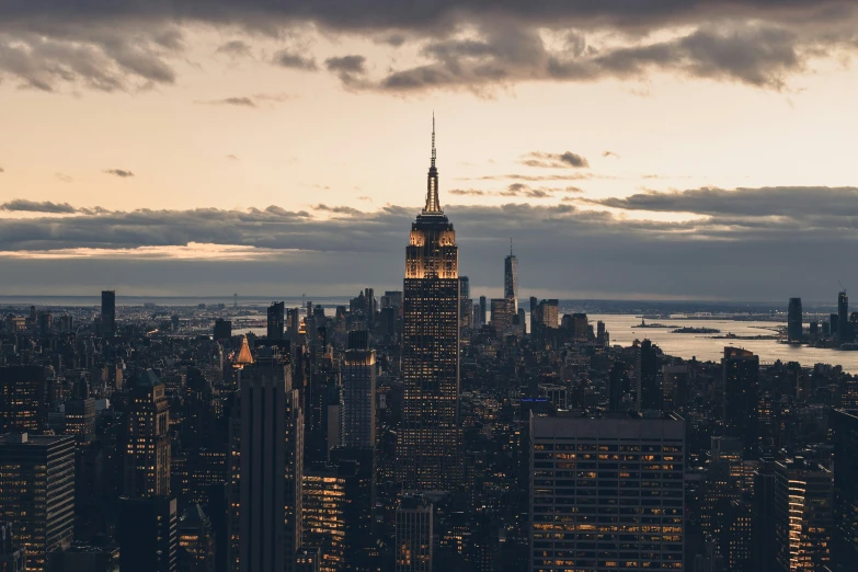 large cityscape lit up at night under cloudy sky