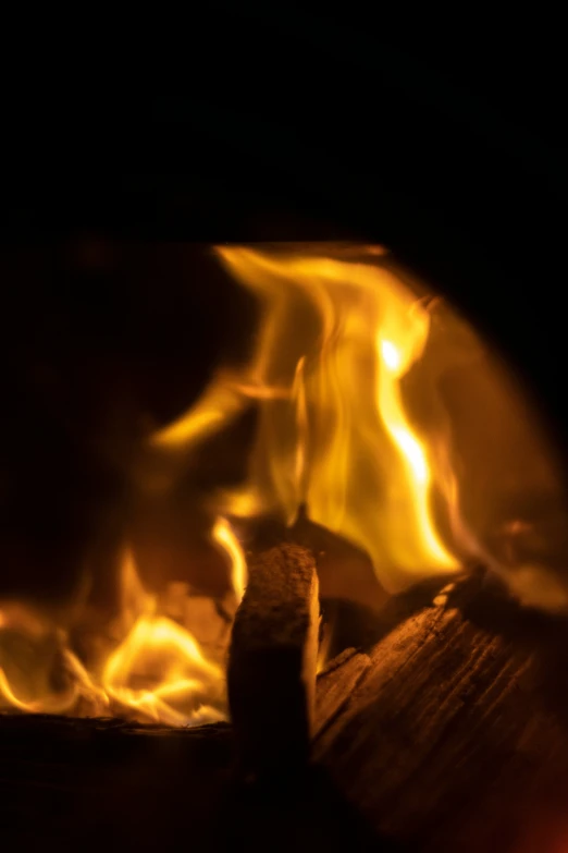 the light from inside a wood burning fireplace shines bright