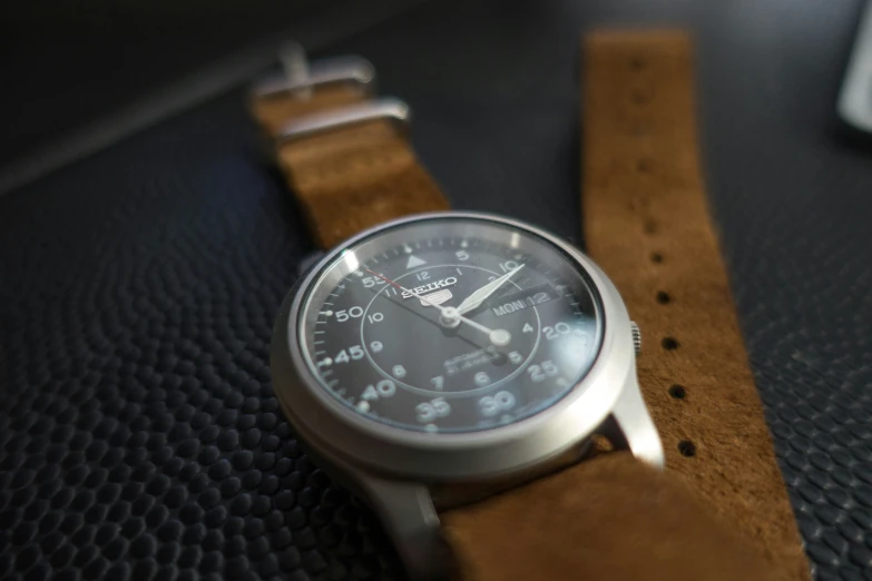 a watch is shown on a leather strap