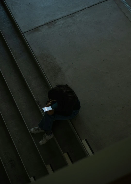 a woman is sitting on stairs on her phone