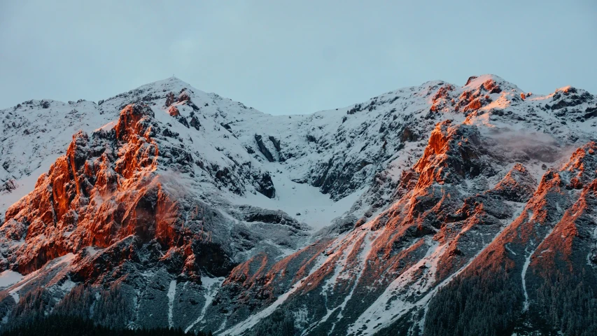 a snowy mountain top covered in a dusting of pink