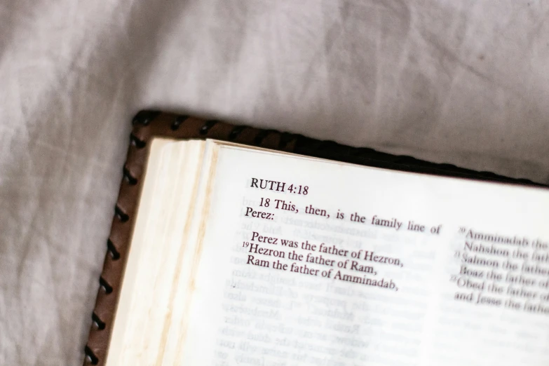 an open book sitting on top of a blanket