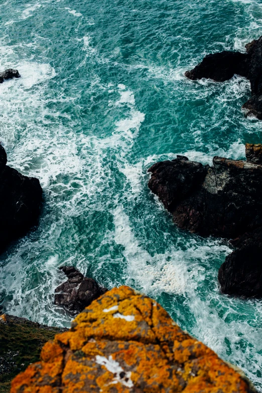 a small boat on the ocean near a rocky shore