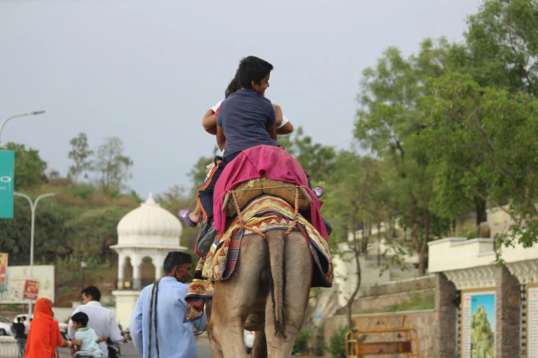 woman and child ride a camel in india