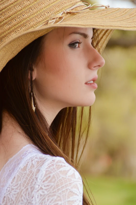 a pretty woman wearing a yellow hat on top of a lush green field