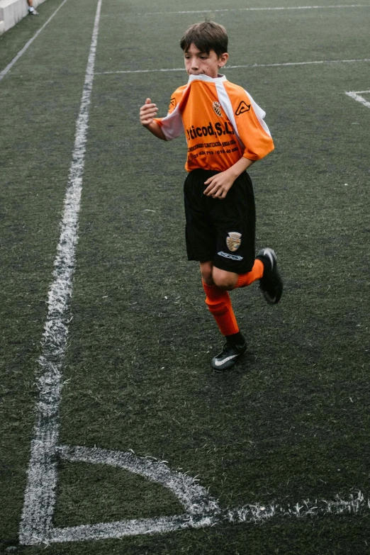 a  in an orange and black uniform is playing soccer