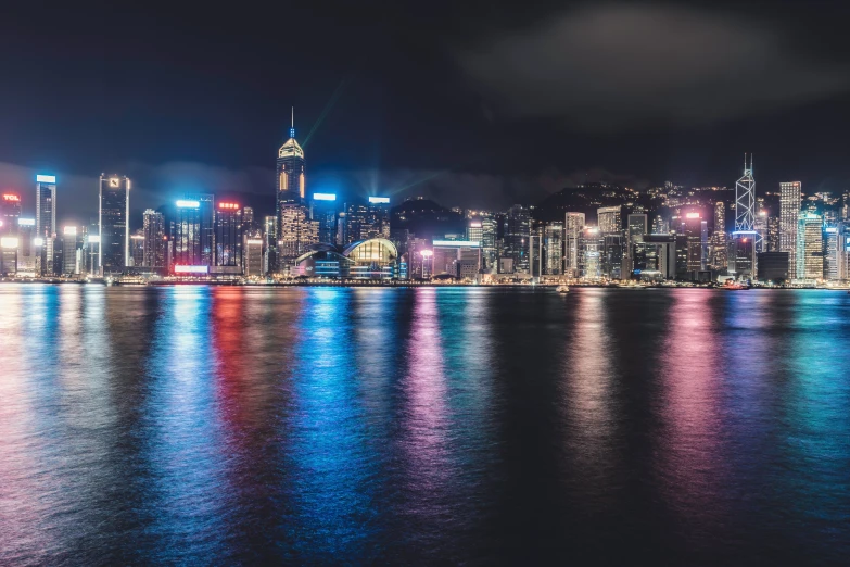 a city view with lights on and buildings reflected in the water