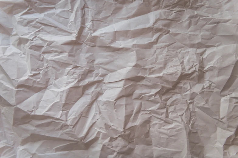 wrinkled paper sitting on a bed cover
