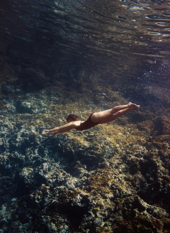 a  woman swimming underwater above the water