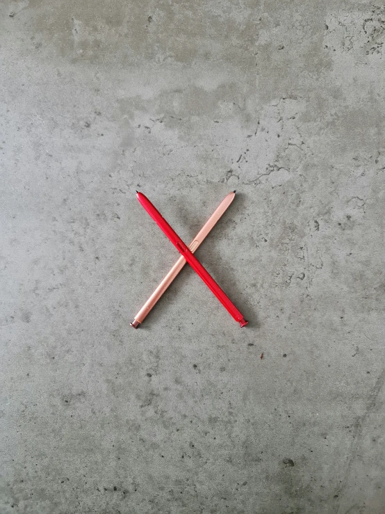 a small crossed pencil sits on the cement