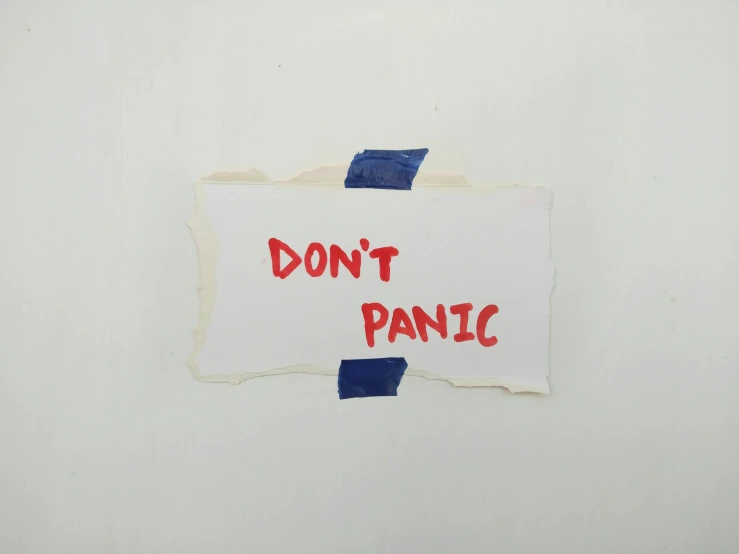 a sign that says don't panic hangs on a wall