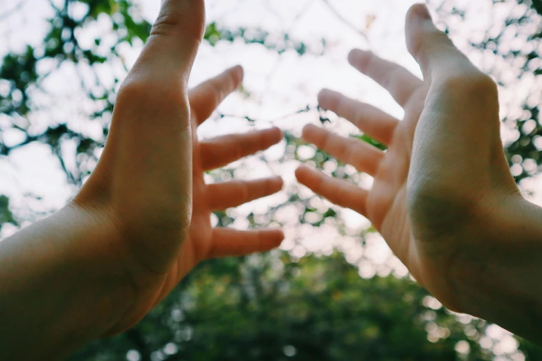 two hands reach for each other on a blurry background