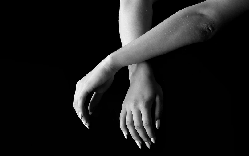 a female holding out her hands with a black background