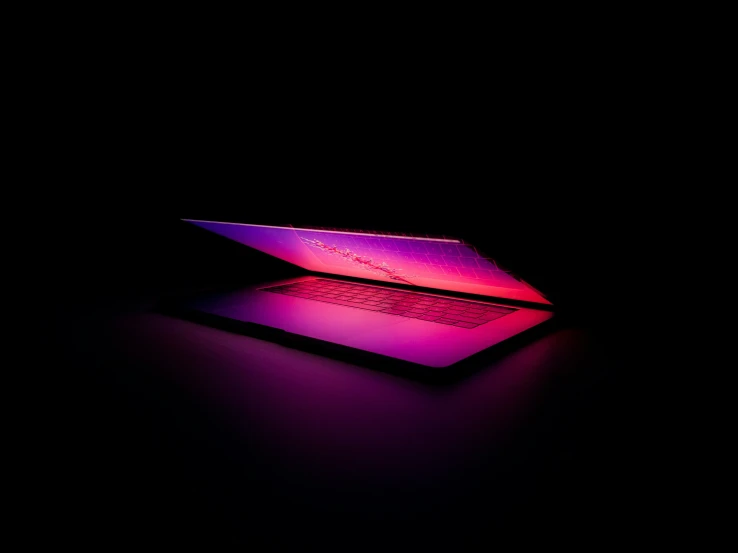 a purple laptop sits in the dark
