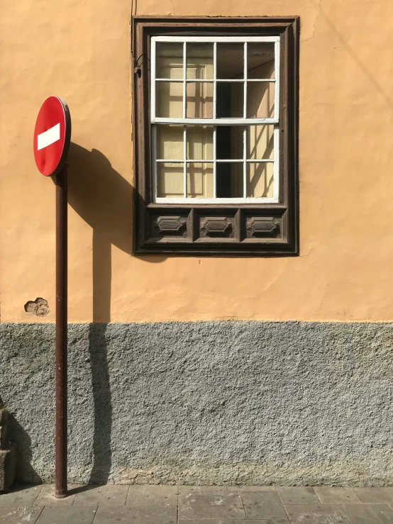 a stop sign near a light pole on a sidewalk