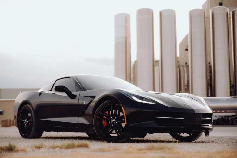 a black and orange sports car in front of some tall buildings