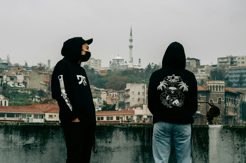two men looking over a city from a roof